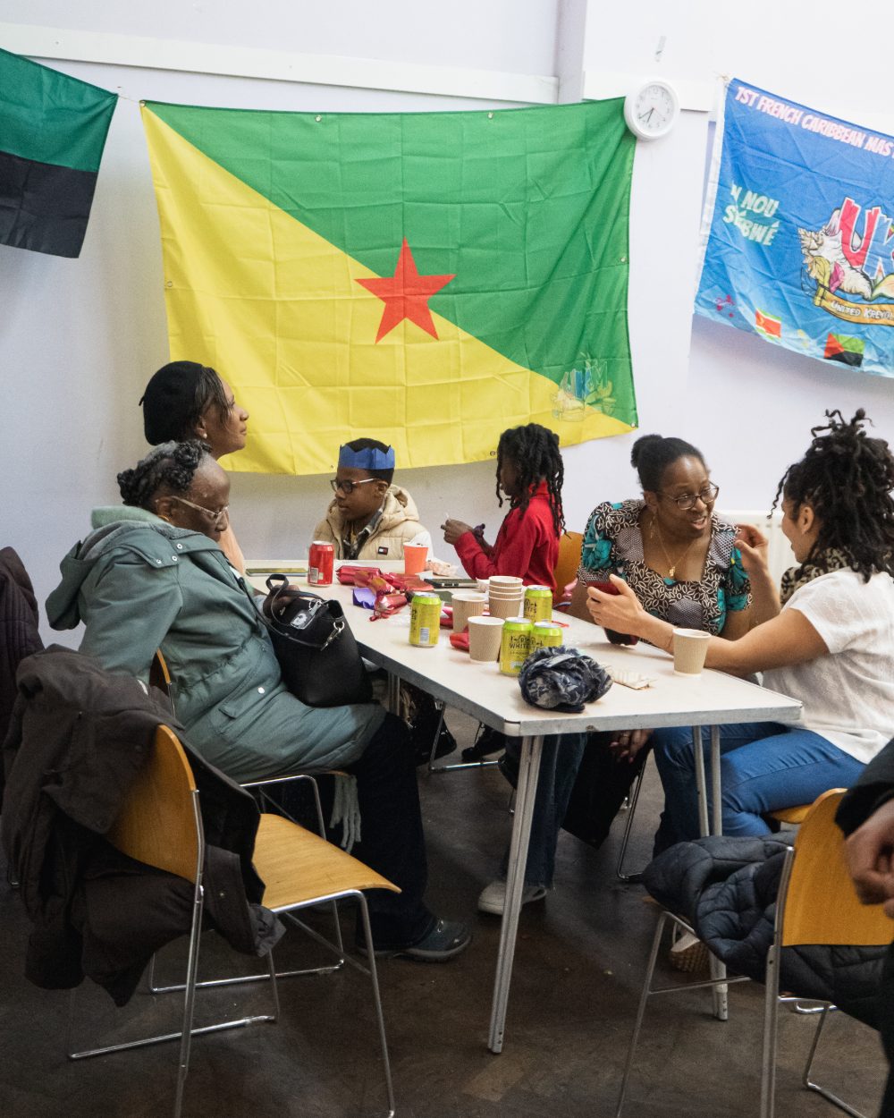 Three generations sharing a table under French Caribbean flags